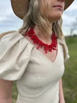 Collar corto estilo babero de IneGug, compuesto por ramas de imitación coral en color rojo intenso con acabado brillante.