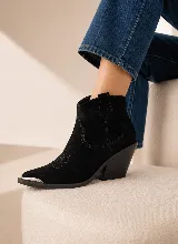 Bota corta estilo western de cuero negro, con taco cuadrado y punta fina reforzada con detalle metálico. Presenta costuras decorativas en el empeine y laterales.
