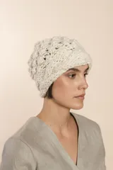 Gorro tejido a mano con hilado rueca, color beige. Presenta variedad de texturas: punto garbanzo y guarda con diseño de trenzas.