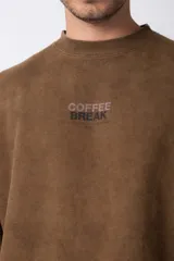 Buzo de cuello redondo en algodón rústico con efecto de lavado gastado, corte oversize y estampa frontal pequeña con texto.