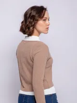 Top marrón de punto, manga larga y escote en V con cierre de dos botones. Incluye una remera blanca de cuello alto debajo.