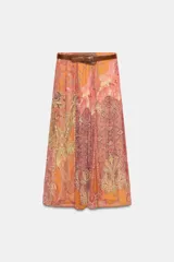 Falda midi de corte fluido con estampado paisley en tonos naranja, rosado y beige. Presenta cintura elástica y viene acompañada de un cinturón de cuero sintético marrón con hebilla metálica. Incluye forro interior.