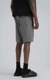 Short de baño gris oscuro, confeccionado en microfibra de secado rápido. Presenta cierre frontal con velcro y cordón, y tres bolsillos con cierre (dos laterales y uno trasero).