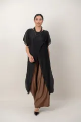 Maxi blusón negro de seda con diseño asimétrico en picos y mangas cortas fluidas.