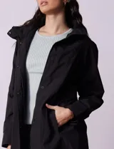 Campera impermeable color gris claro, marca Gallery. Tiene abertura central con cierre oculto y botones a presión, bolsillos delanteros y capucha plegable en el cuello.