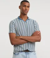 Remera polo de punto texturizado para hombre, de manga corta, con diseño a rayas verticales en tonos azul y blanco, cuello polo celeste y escote en V sin botones.