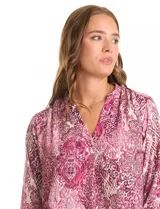 Blusa de gasa con estampado geométrico y paisley en tonos fucsia y blanco. Presenta cuello mao con escote en V, mangas tres cuartos con presilla y botón para regular el largo.