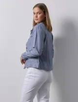 Camisa tipo campera de lino marca Dash, color blanco, con cierre frontal de botones, cuello camisero y bolsillos con solapa en el pecho.
