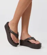 Ojota flatform color marrón, de suela alta y plana, con tiras anchas acolchadas y diseño de dedo.