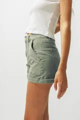 Short de denim color verde oliva, de tiro medio/alto, con silueta recta y calce relajado. Presenta bolsillos delanteros y traseros, y dobladillo enrollado.