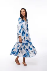 Vestido midi blanco con estampado floral en tonos de azul, corte evasé, mangas 3/4 y cuello en V.