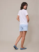 Short de jean elastizado en color azul claro, de tiro alto con cierre y botón metálico, diseño clásico de cinco bolsillos con costuras a contratono.