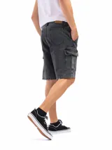 Bermuda de jean azul oscuro, estilo cargo, con bolsillos laterales con tapa a la altura del muslo.