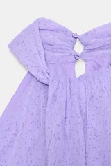 Top corto de cuello halter con diseño delantero cruzado y bajo abullonado con elástico. Presenta un estampado sutil de lunares y cierre en la espalda con botones ocultos.
