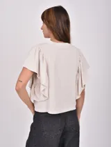 Remera verde de manga corta con volados en los hombros y escote redondo.