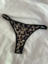 Bombacha tipo colaless con estampado animal print de leopardo y bordes en color negro. Presenta tiras laterales regulables.