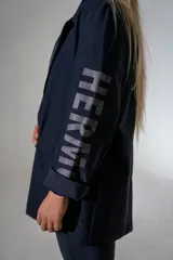 Blazer de lycra color negro, con diseño de solapas amplias y bordados de alas en el frente. Presenta un corte holgado y moderno con mangas largas.