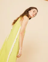 Vestido largo blanco de lino con escote en V y flecos de algodón en los bordes.