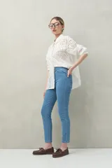 Pantalón chupín negro de tiro alto, confeccionado en denim suave y levemente elástico, con bolsillos delanteros y traseros.