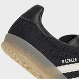 Championes Adidas Gazelle Indoor color negro con las tres tiras blancas y suela color caramelo.