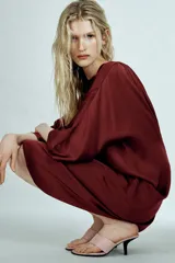 Vestido midi de Zara Woman Collection confeccionado en viscosa satinada, color bordó. Presenta cuello barco, mangas por debajo del codo y bajo recto, con detalle de lazo fino en la parte posterior del cuello.