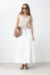 Maxi falda blanca de jean con corte evasé, cintura alta y cierre frontal con cremallera.