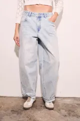 Jean de corte baggy con silueta barrel, tiro medio y lavado claro. Presenta costuras reforzadas en las rodillas y ruedo con doblez.