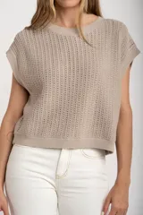 Chaleco sin mangas de tejido de punto color rosado pálido, con textura calada y acabado lurex, corte al cuerpo y cuello redondo.