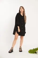 Camisa negra oversize de manga larga con cuello camisero y cierre frontal con botones.