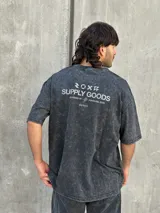 Remera gris con efecto gastado, corte oversize, mangas cortas y estampado en la espalda con el texto "SUPPLY GOODS DESIGNED IN PUNTA DEL ESTE".