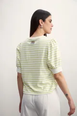 Remera de algodón con estampado de rayas horizontales en color verde claro sobre fondo blanco, con mangas cortas abullonadas y puños lisos.