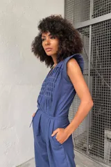Mono azul de lino y algodón texturizado con plisados de pespuntes de color en contraste. Tiene lazo en la cintura, fuelle en la espalda y mangas texturizadas.