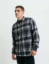 Camisa de franela a cuadros con cuello button-down, manga larga y botones de madera. Presenta dos bolsillos tipo parche en el frente con cierre de botón.