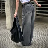Jean Aloudra de corte wide leg en color gris con efecto acid wash. Presenta bolsillos traseros con detalles bordados de llamas.