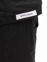 Remera de lino con corte holgado, cuello redondo y mangas cortas. Presenta un diseño minimalista con detalle de botones en la espalda.