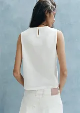 Top blanco sin mangas de algodón, con cuello redondo y detalles bordados.