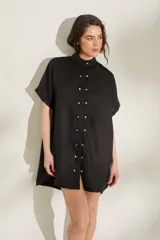 Vestido negro de lino con moldería amplia, cuello mao, mangas cortas y botones dorados frontales.