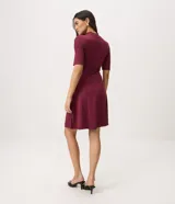 Vestido midi evasé color bordó, con cuello alto, mangas cortas y cintura marcada con cinturón fino removible con hebilla metálica dorada.