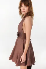 Vestido corto color amarillo de lino italiano, con escote halter cruzado en V pronunciado y cintura elastizada fruncida con falda amplia y voluminosa.