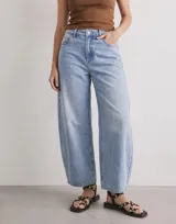 Jean de denim celeste de tiro alto, con diseño barrel y corte baggy de perneras amplias.
