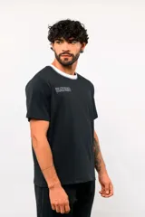 Remera de manga corta Umbro color blanco, con cuello redondo en tono azul oscuro y el logo de la marca bordado en el pecho.