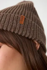 Gorro tipo beanie de tejido acanalado en color marrón taupe, con diseño clásico y ajuste cómodo.
