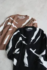 Sweater negro con estampado abstracto en color blanco, de corte holgado y mangas largas.