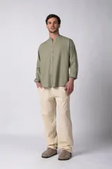 Camisa de manga larga confeccionada en lino, con cuello mao y cierre frontal de botones. Presenta un corte relajado y diseño minimalista.