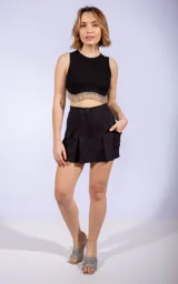 Short negro de tiro medio con pinzas delanteras, bolsillos laterales tipo cargo y cierre frontal con botón.