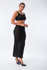 Pollera midi de tejido de punto calado en color negro, con diseño de rayas diagonales y tajo lateral profundo.