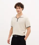 Polo de manga corta con textura en relieve, cuello tipo polo con abertura frontal sin botones y detalles de líneas contrastantes en cuello y puños.