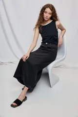 Falda larga de denim negro con diseño a rayas verticales y calce recto, tiro medio, bolsillos y cierre con botón.