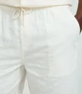 Bermuda masculina color crudo, confeccionada en tejido texturizado de algodón y viscosa con patrón vertical.