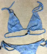 Top de bikini azul con tirantes finos y corte triangular.